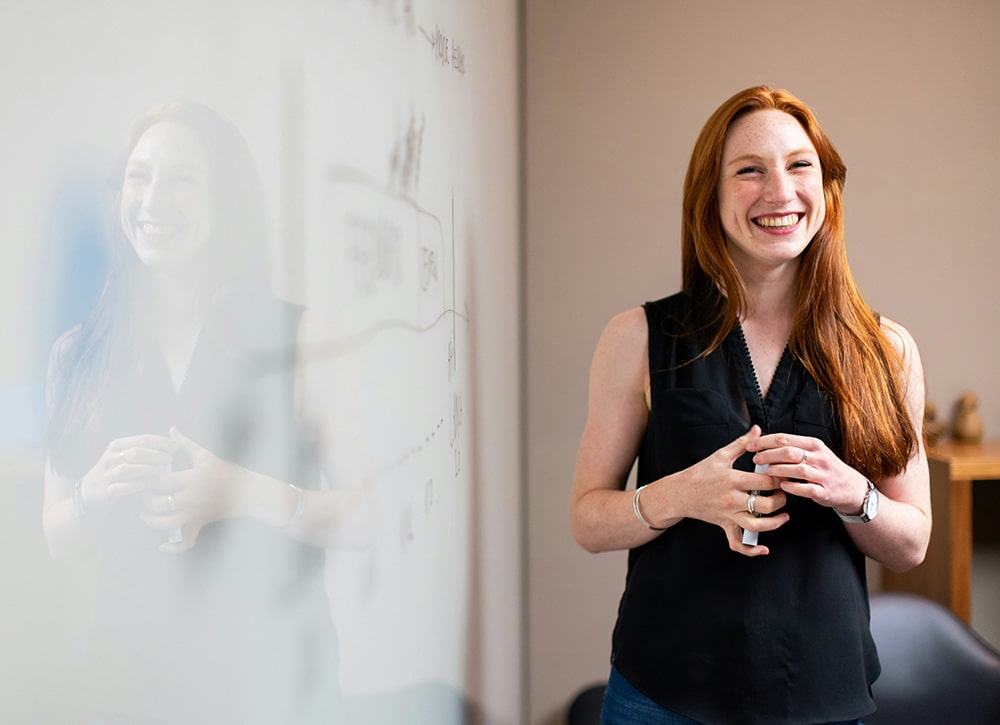 Woman presents report on whiteboard