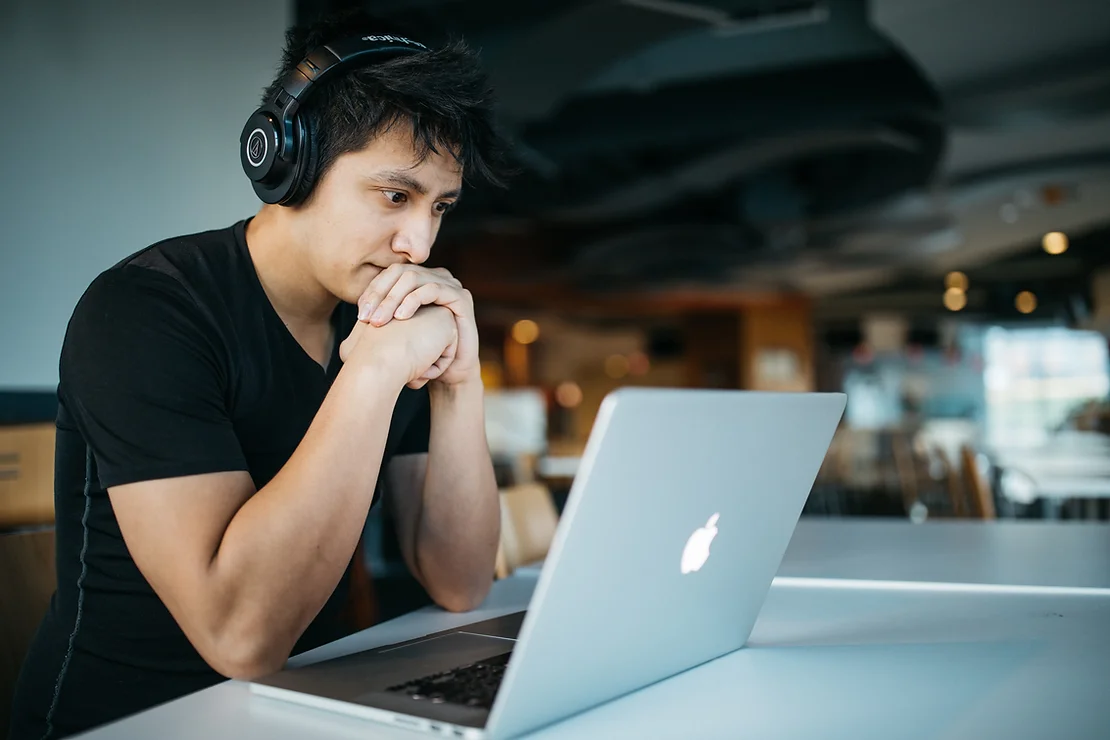 Man works at laptop with headphones